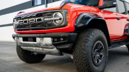 خودروی فورد برانکو رپتور (Ford Bronco Raptor) قرمز رنگ با لاستیک‌های آفرود