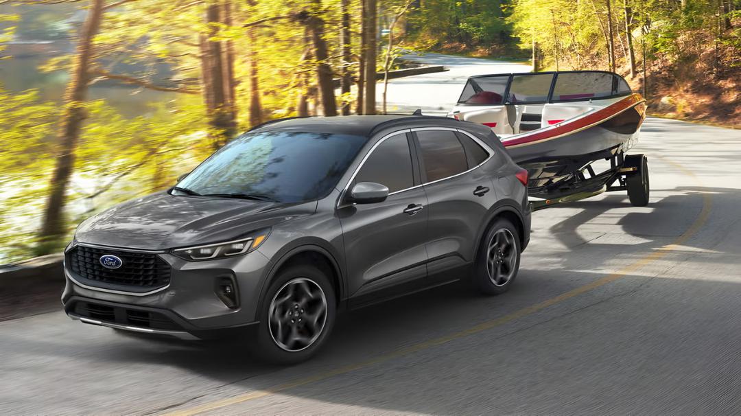 خودرو فورد (Ford) هیبریدی در حال حمل قایک با تریلر در جاده جنگلی