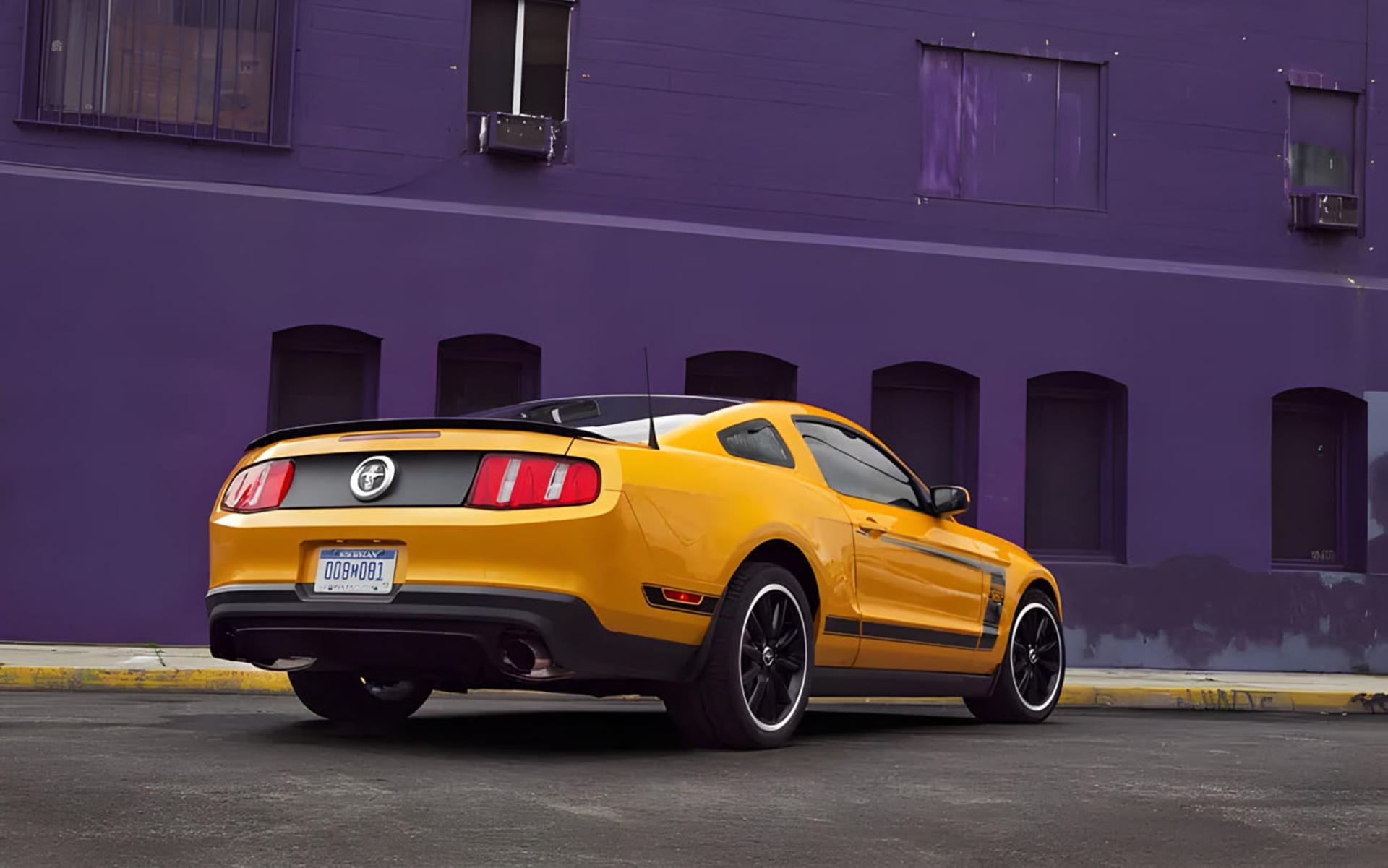 خودروی زرد رنگ فورد موستانگ باس 302 (Ford Mustang Boss 302) در مقابل یک ساختمان بنفش