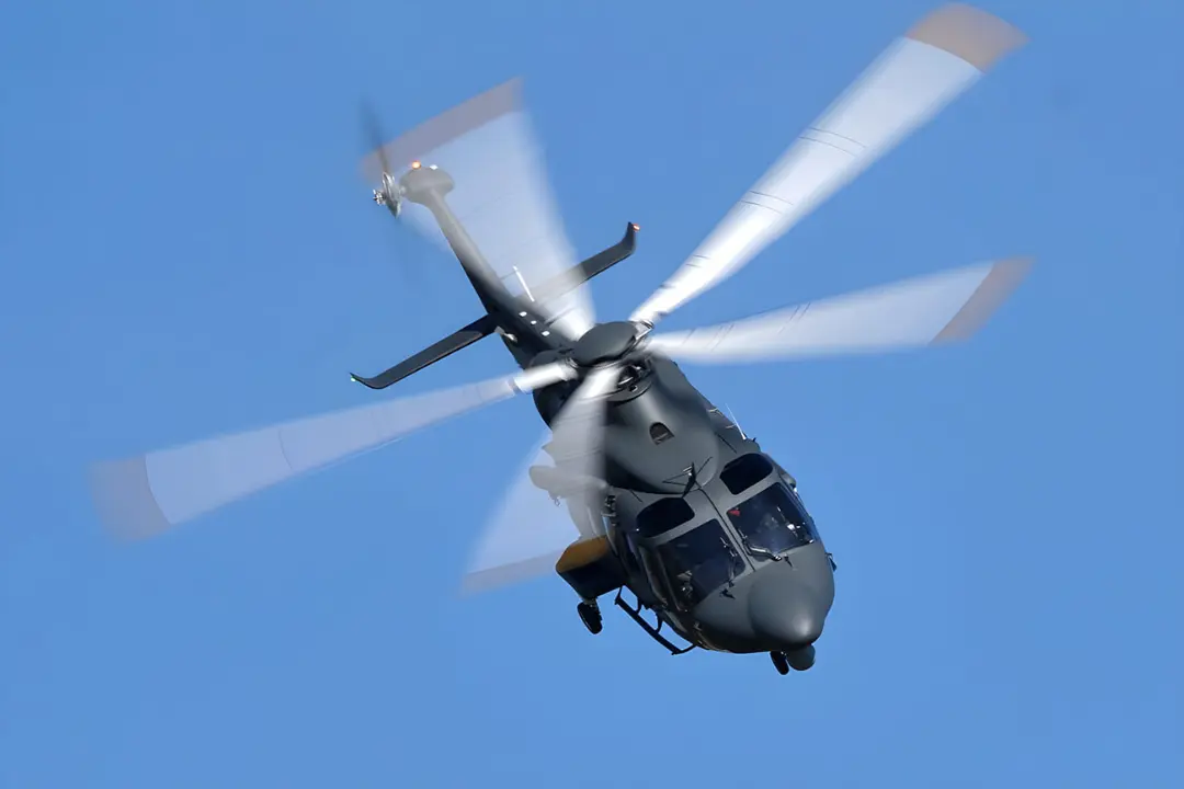 بالگرد (Helicopter) در حال پرواز با پره‌های چرخان در آسمان آبی