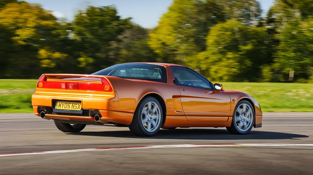 خودرو اسپرت هوندا (Honda) NSX نارنجی در حال حرکت در پیست مسابقه