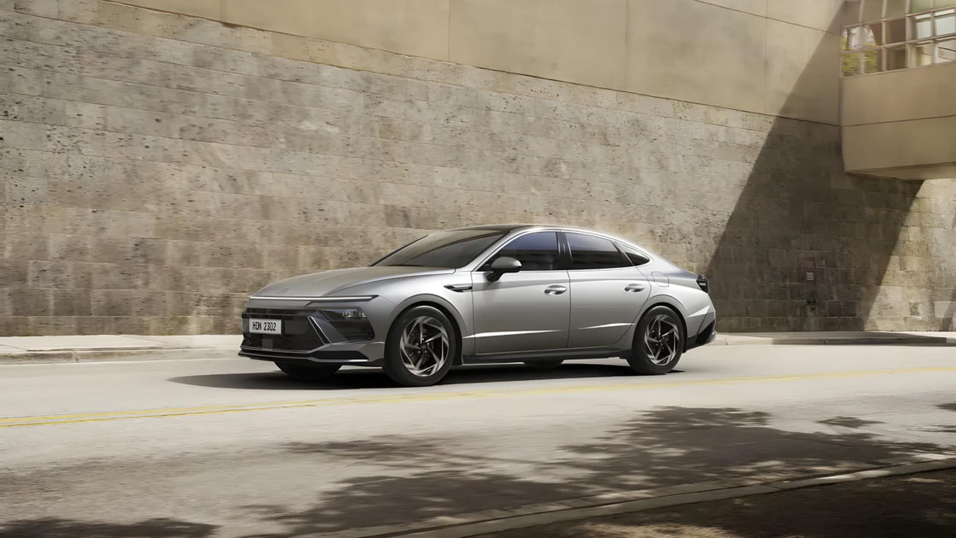 خودرو هیوندای (Hyundai) نقره‌ای در حال حرکت در جاده شهری