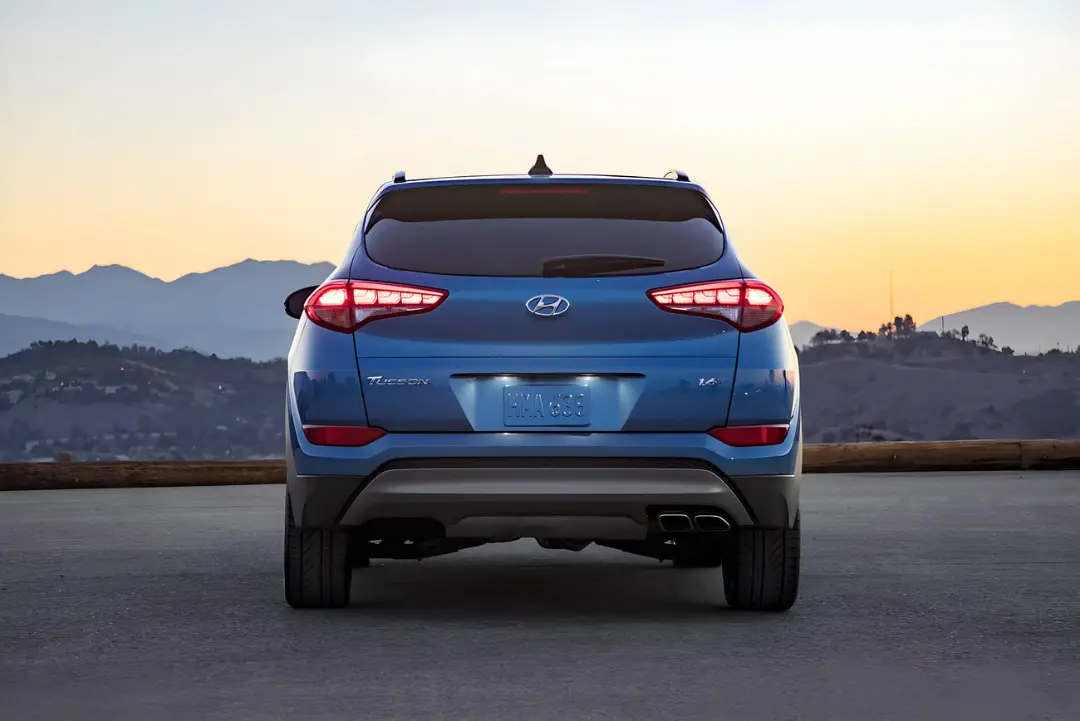 نمای عقب خودروی آبی‌رنگ هیوندای توسان (Hyundai Tucson) در هنگام غروب