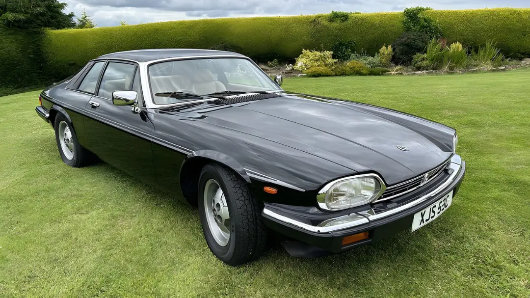 خودرو کلاسیک جگوار (Jaguar) مدل XJS با بدنه مشکی در فضای سبز