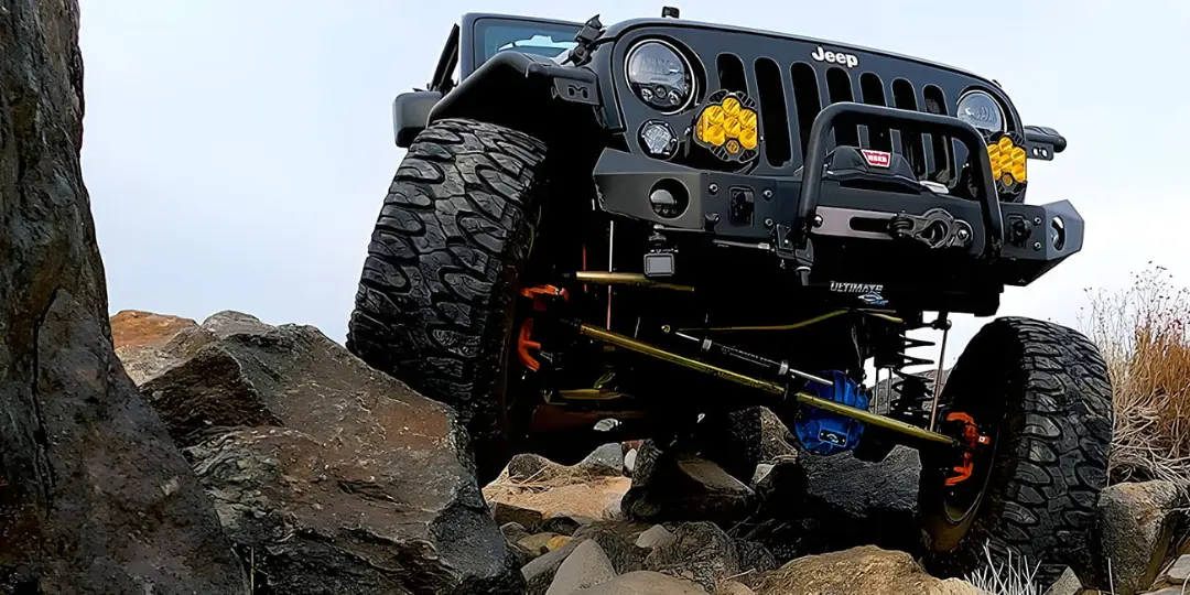 خودروی جیپ (Jeep) در حال عبور از صخره‌های ناهموار در مسیر آفرود