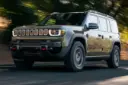جیپ ریکان (Hummer EV) در حال حرکت در جاده‌ای میان درختان