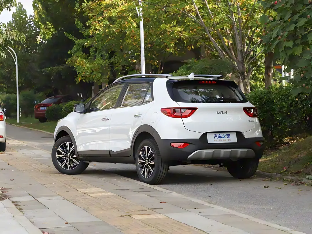 خودرو سفید رنگ کیا استونیک (Kia Stonic) در جاده‌ای در کنار درختان