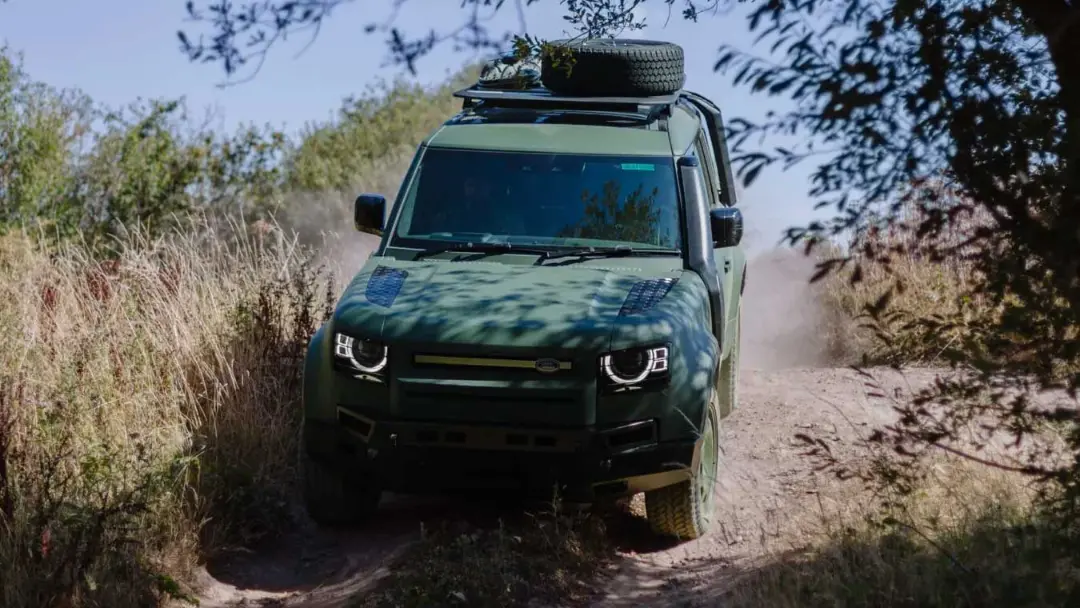 خودروی نظامی لندروور دیفندر (Land Rover Defender) در حال حرکت در مسیر خاکی