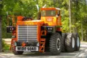 کامیون غول‌پیکر ماک (Mack M100SX) با رنگ نارنجی در محیط جنگلی