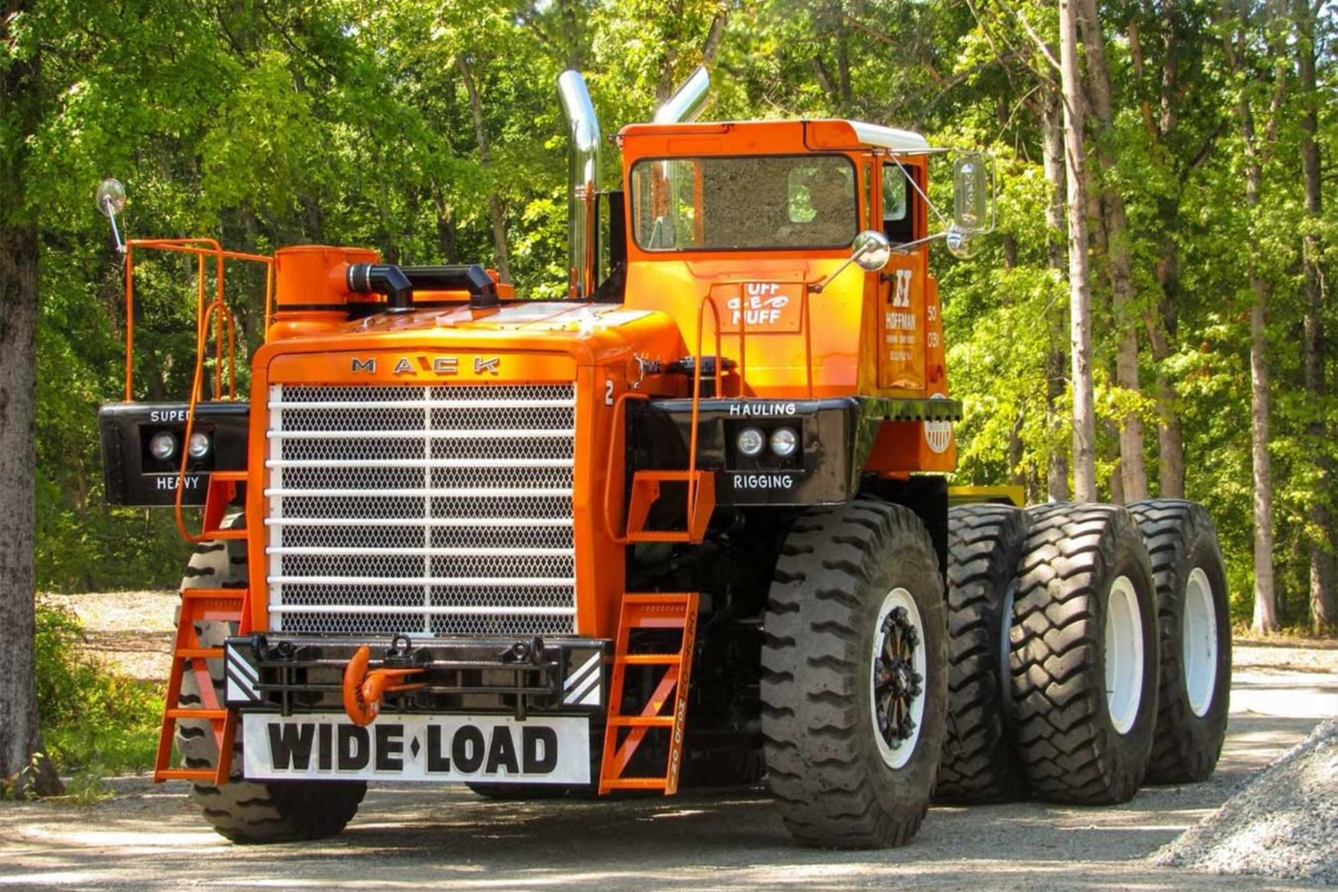 کامیون غول‌پیکر ماک (Mack M100SX) با رنگ نارنجی در محیط جنگلی