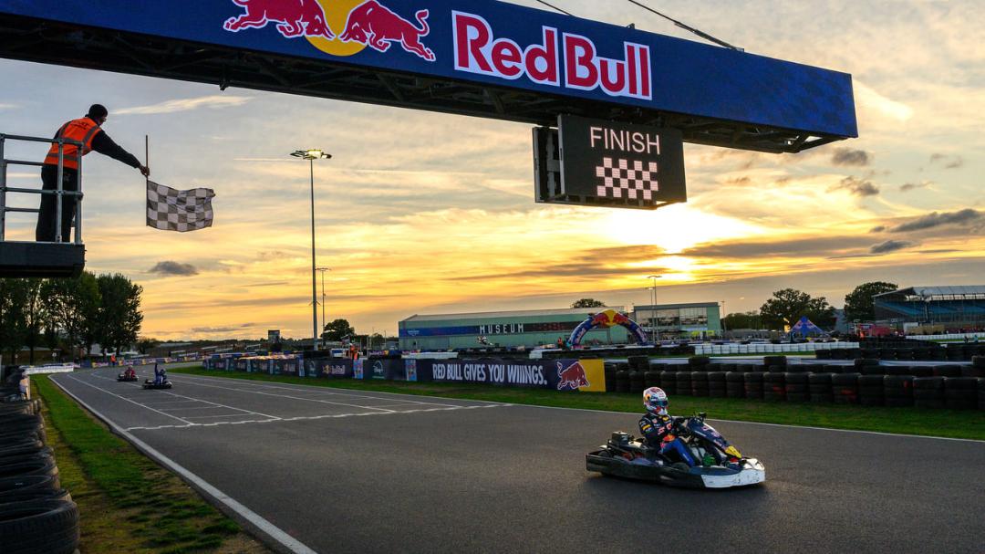 راننده کارتینگ (Karting) در حال عبور از خط پایان مسابقه در غروب