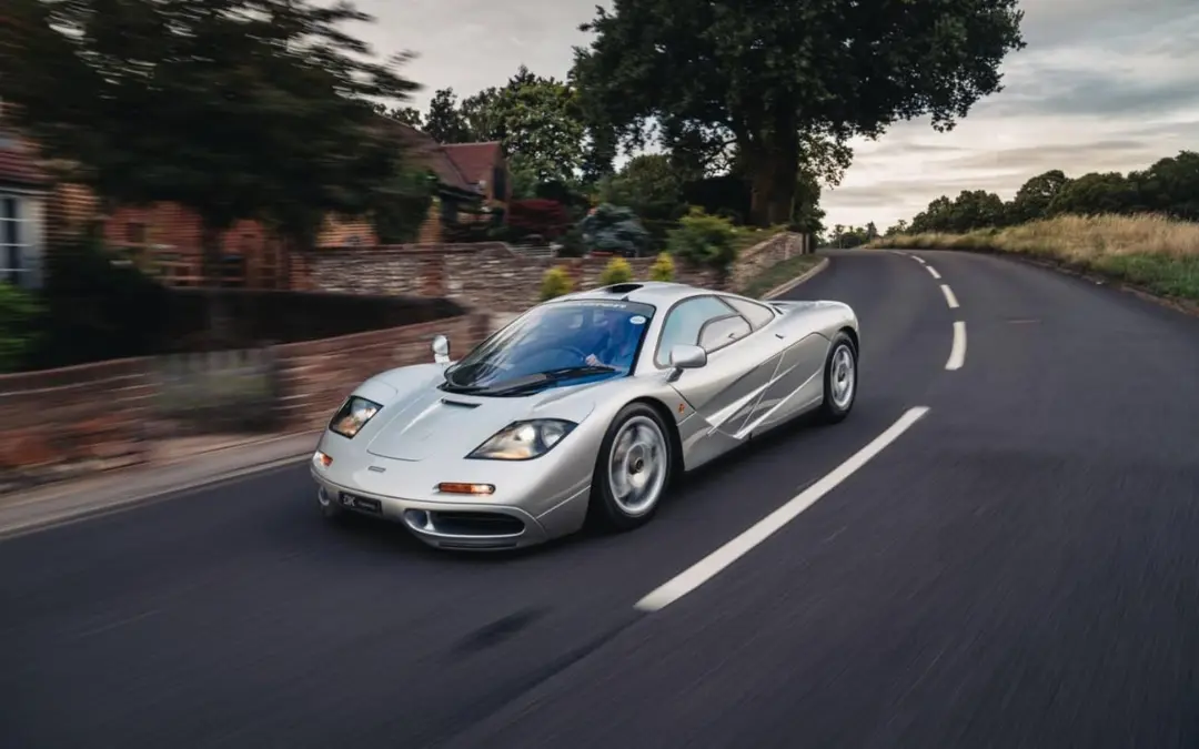 خودرو مک‌لارن F1 (McLaren F1) با رنگ نقره‌ای در حال حرکت در جاده
