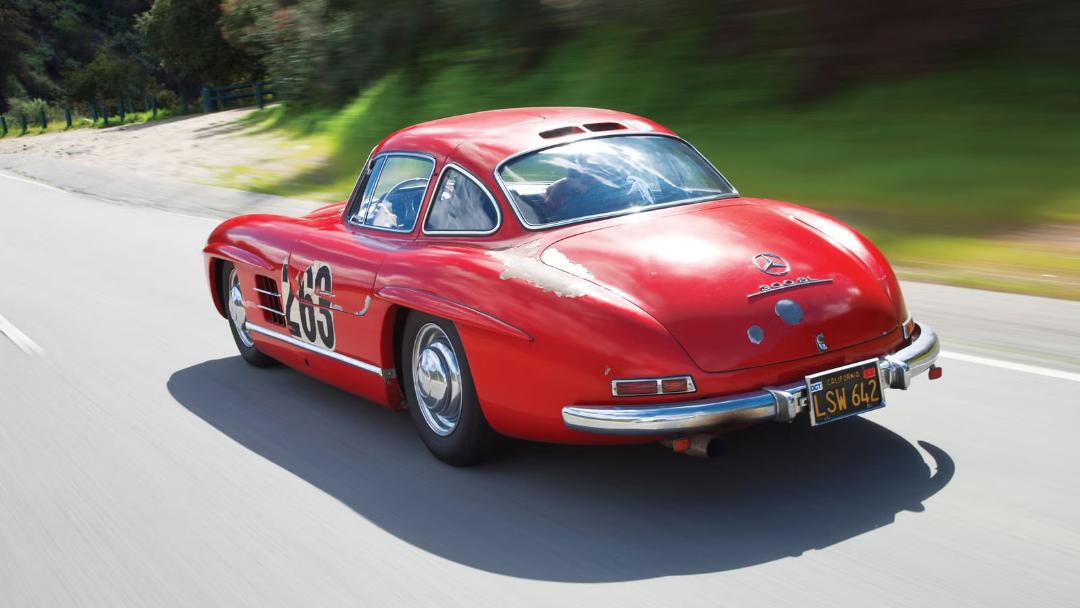خودروی کلاسیک مرسدس بنز 300 SL (Mercedes-Benz 300 SL) قرمز در حال حرکت در جاده