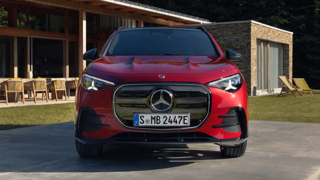 خودروی برقی مرسدس بنز (Mercedes-Benz) قرمز رنگ در مقابل یک ساختمان مدرن
