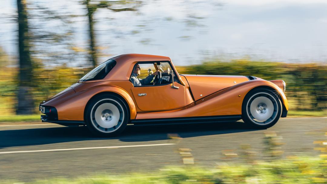 خودرو نارنجی‌رنگ مورگان سوپراسپرت (Morgan Supersport) در حال حرکت در جاده