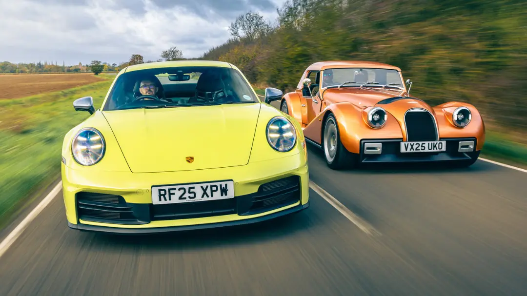 پورشه 911 کاررا T (Porsche 911 Carrera T) زرد رنگ در کنار مورگان سوپراسپرت نارنجی در حال حرکت