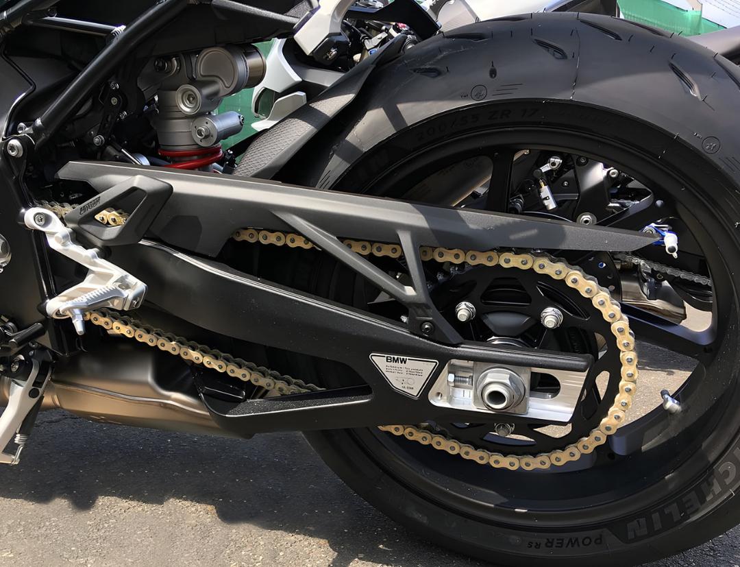 زنجیر موتورسیکلت (Motorcycle Chain) و چرخ عقب روی بدنه مشکی