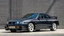 خودرو اسپرت نیسان 400R (Nissan 400R) با رنگ مشکی در مقابل دیوار خاکستری