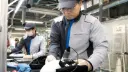 کارگر ژاپنی در خط تولید خودرو نیسان (Nissan) مشغول بازرسی قطعات است