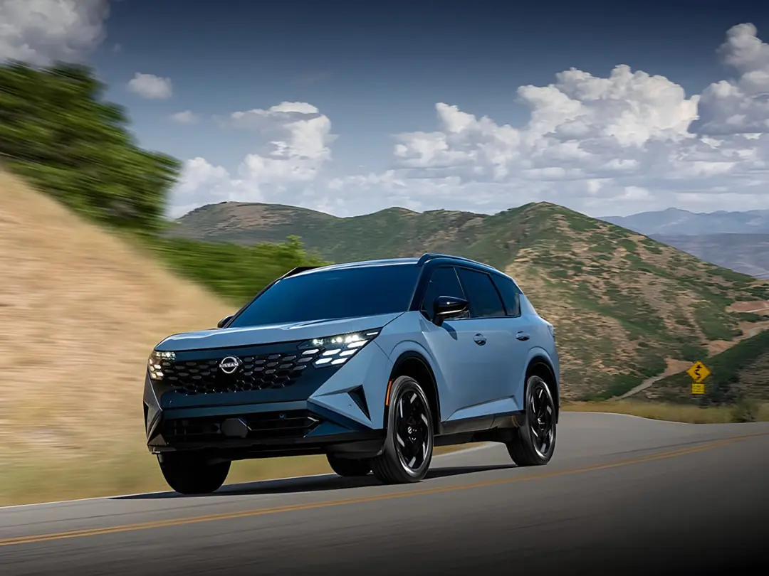 خودرو نیسان (Nissan) در حال حرکت در جاده‌ای کوهستانی