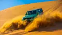 خودروی آفرود در حال حرکت سریع روی تپه‌های شنی و ایجاد گرد و غبار