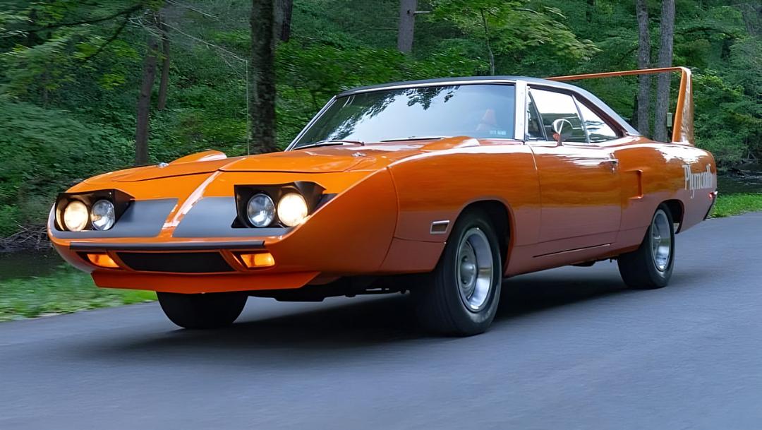 خودروی نارنجی رنگ دوج داوجارگ (Dodge Charger) در حال حرکت در جاده جنگلی