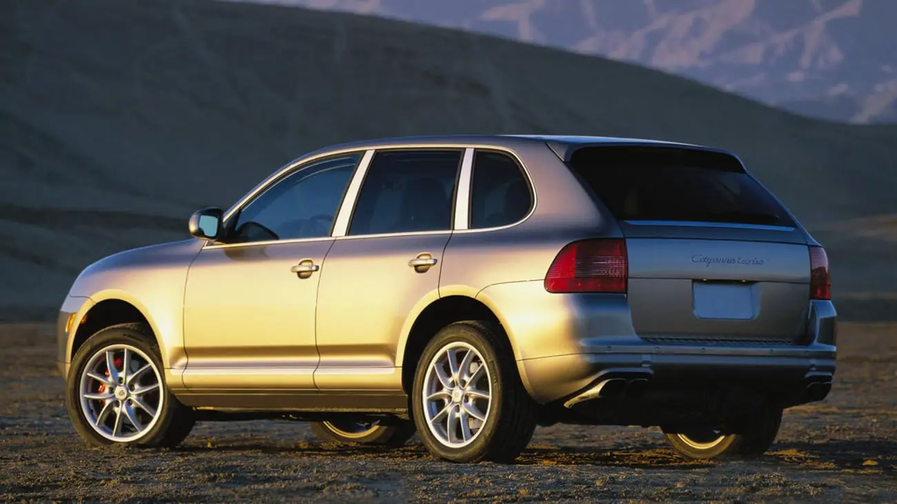 خودروی پورشه کاین (Porsche Cayenne) نقره‌ای در محیط کویری