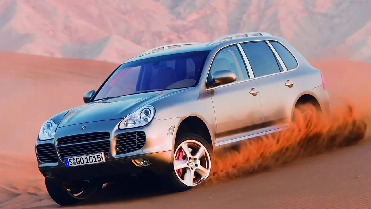 خودرو پورشه کاین (Porsche Cayenne) در حال حرکت در میان شن‌های بیابان
