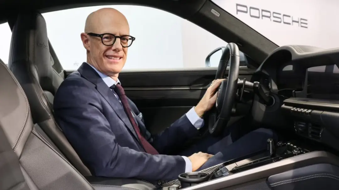 مردی با عینک در صندلی راننده خودروی لوکس پورشه (Porsche)