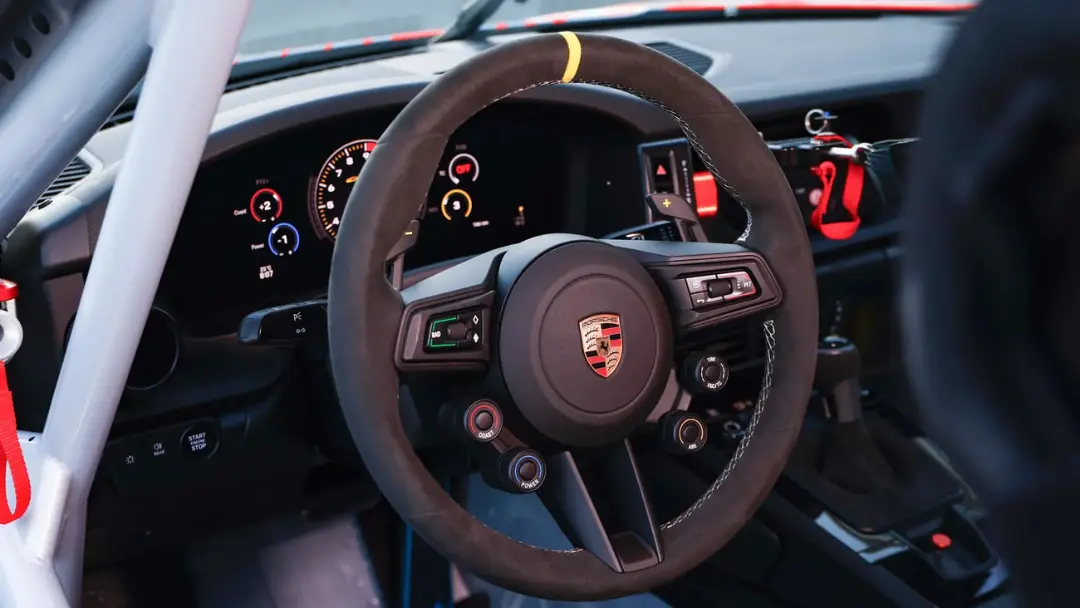 نمای داخلی کابین خودروی پورشه (Porsche) با فرمان و دکمه استارت