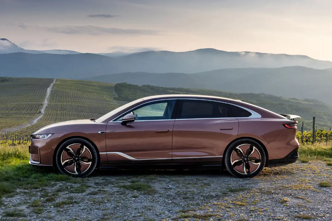 خودرو برقی پشن صدان (Porsche Macan) در مسیر کوهستانی با منظره تاکستان