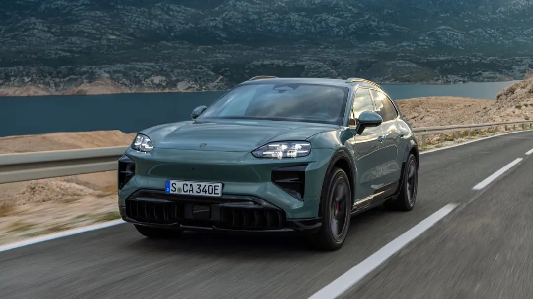 خودرو برقی پورشه ماکان (Porsche Macan EV) در حال حرکت در جاده‌ای کوهستانی