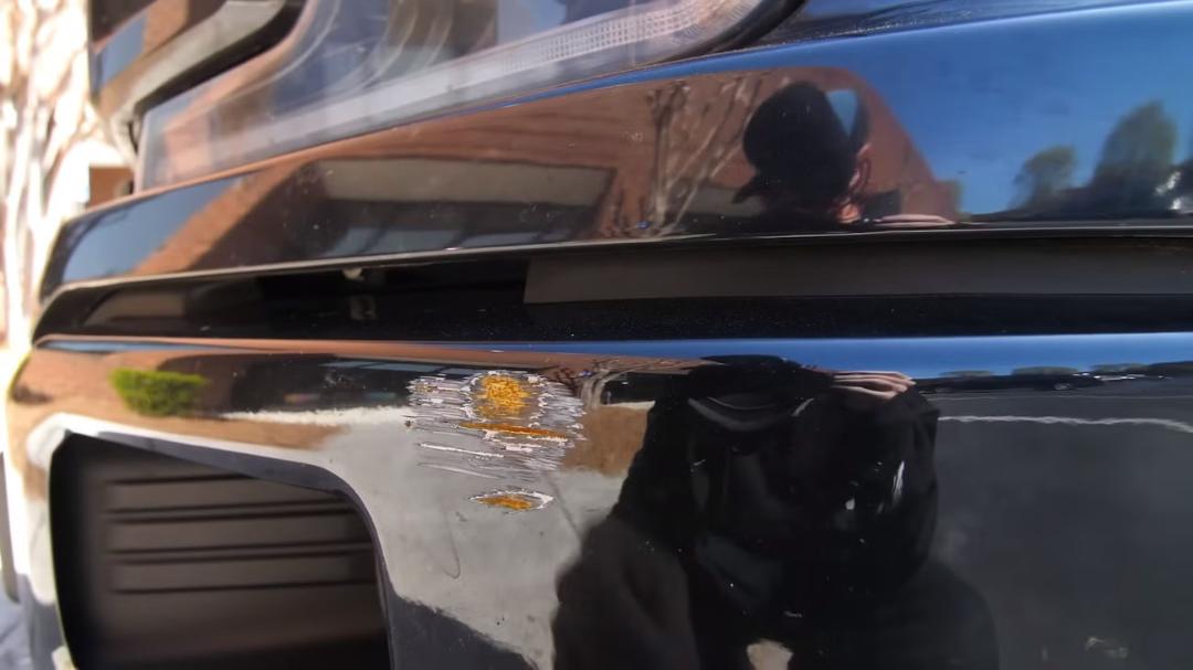 خراش روی سپر جلوی خودروی پورشه تایکان (Porsche Taycan) در رنگ مشکی