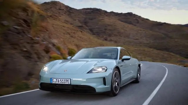 خودروی پورشه تایکان (Porsche Taycan) در حال حرکت در جاده‌ای کوهستانی