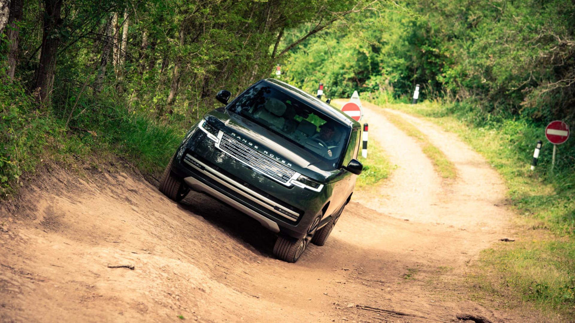 خودرو رنج‌روور (Range Rover) الکتریکی در حال حرکت در مسیر خاکی تپه‌ای