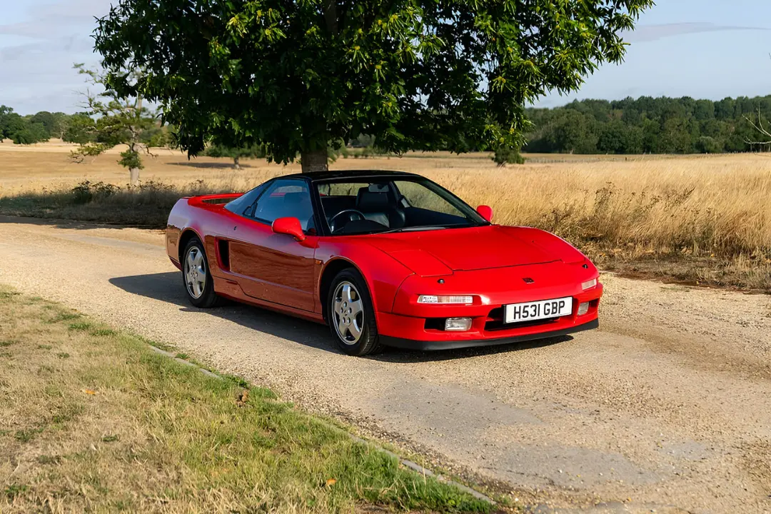 خودرو اسپرت قرمز رنگ هوندا (Honda) NSX در جاده‌ای روستایی