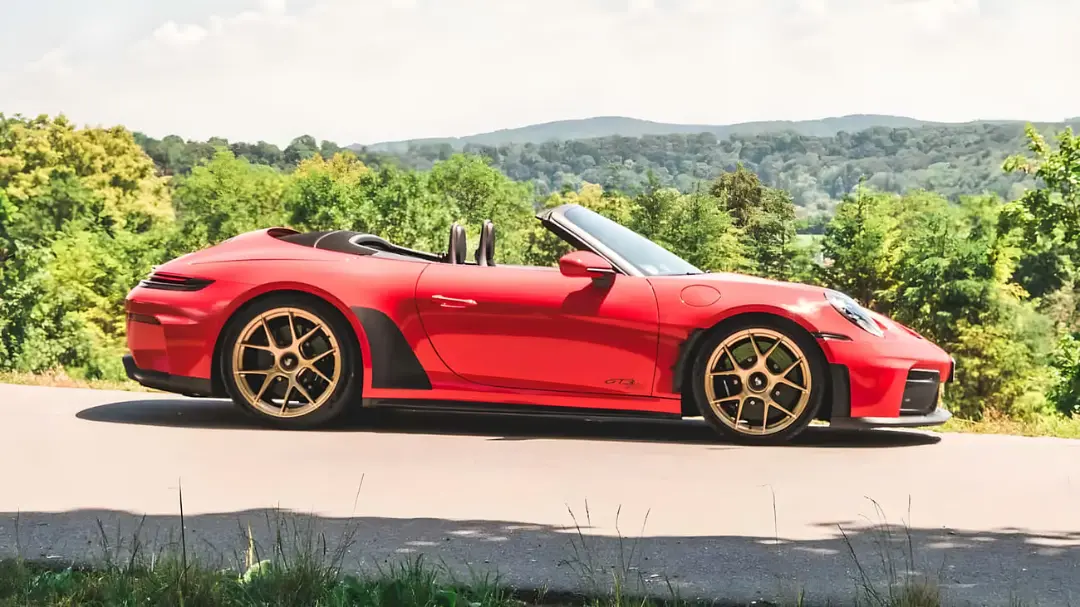 خودرو قرمز پورشه (Porsche) مدل GT3 در جاده‌ای میان طبیعت