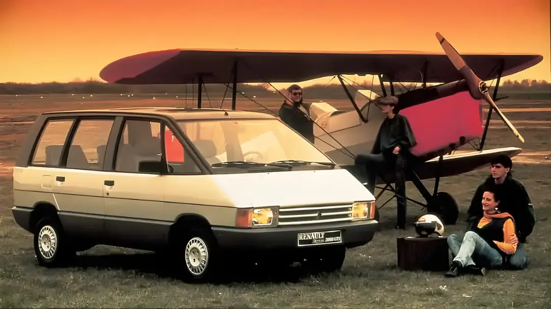 خودرو رنو ای-اسپیس (Renault Espace) در کنار یک هواپیمای دو بال در غروب