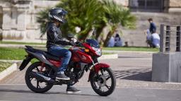 موتورسیکلت هوندا (Honda) قرمز رنگ در حال حرکت در فضای باز