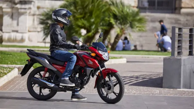 موتورسیکلت هوندا (Honda) قرمز رنگ در حال حرکت در فضای باز