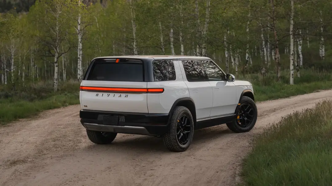 شاسی‌بلند ریویان (Rivian R1S) سفید رنگ در حال حرکت در جاده خاکی