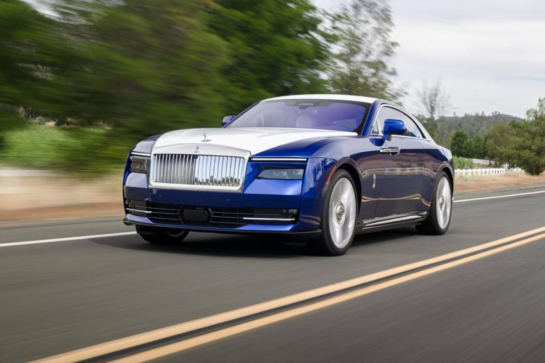 خودرو رولزرویس اسپکتر (Rolls-Royce Spectre) آبی و سفید در حال حرکت در جاده