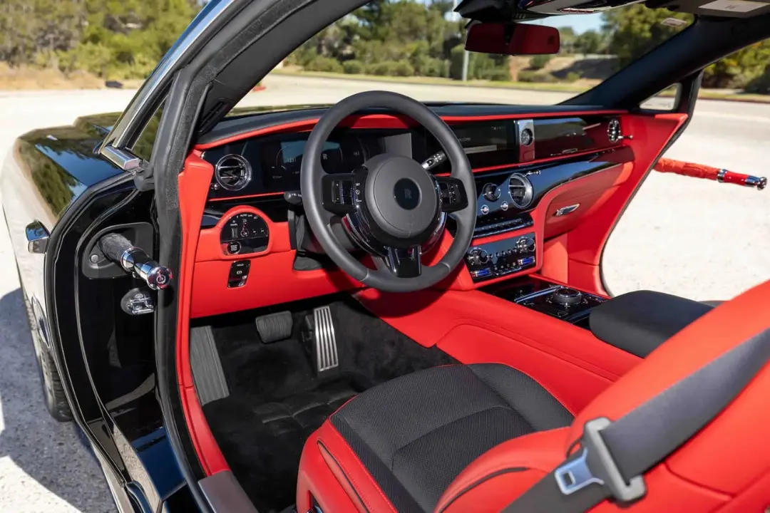 کابین خودروی رولزرویس اسپکتر (Rolls-Royce Spectre) با صندلی‌های قرمز و فرمان مشکی