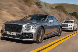 خودروی بنتلی (Bentley) نقره‌ای در حال حرکت در جاده در کنار رولزرویس سفید