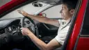 راننده خودرویی با برند اشک (Skoda) در حال تنظیم فاصله دست از فرمان