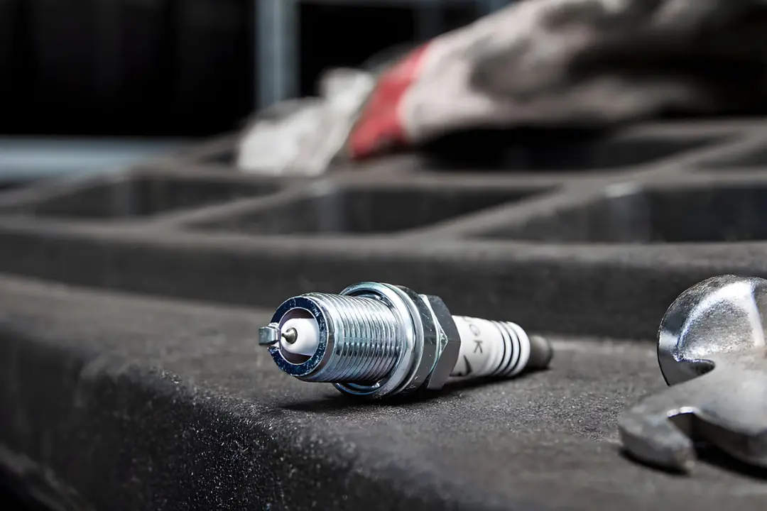 شمع موتور (Spark Plug) روی ابزار کار در تعمیرگاه