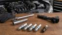 شمع‌های خودرو در کنار یک کوئل (Ignition Coil) و ابزار تعمیرات