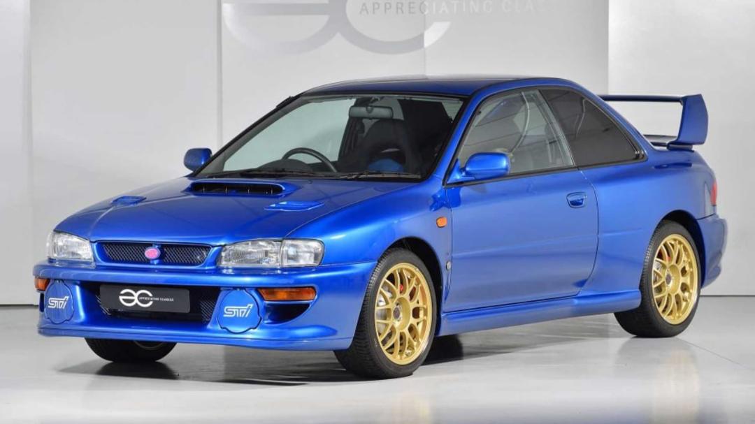 خودرو آبی رنگ سوبارو ایمرزی ورชัน جی تی (Subaru Impreza WRX STI) با رینگ‌های طلایی