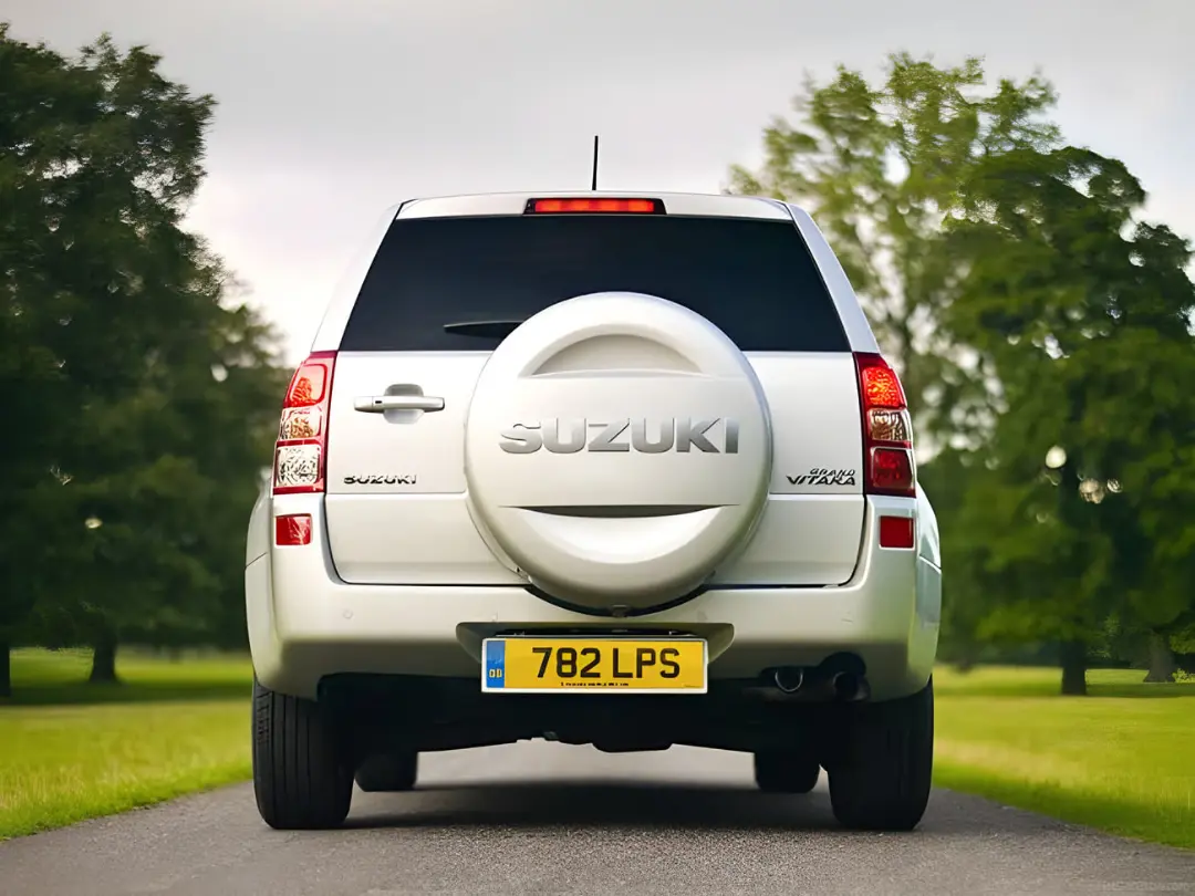 نمای عقب خودروی سوزوکی ویتارا (Suzuki Vitara) در جاده‌ای میان درختان