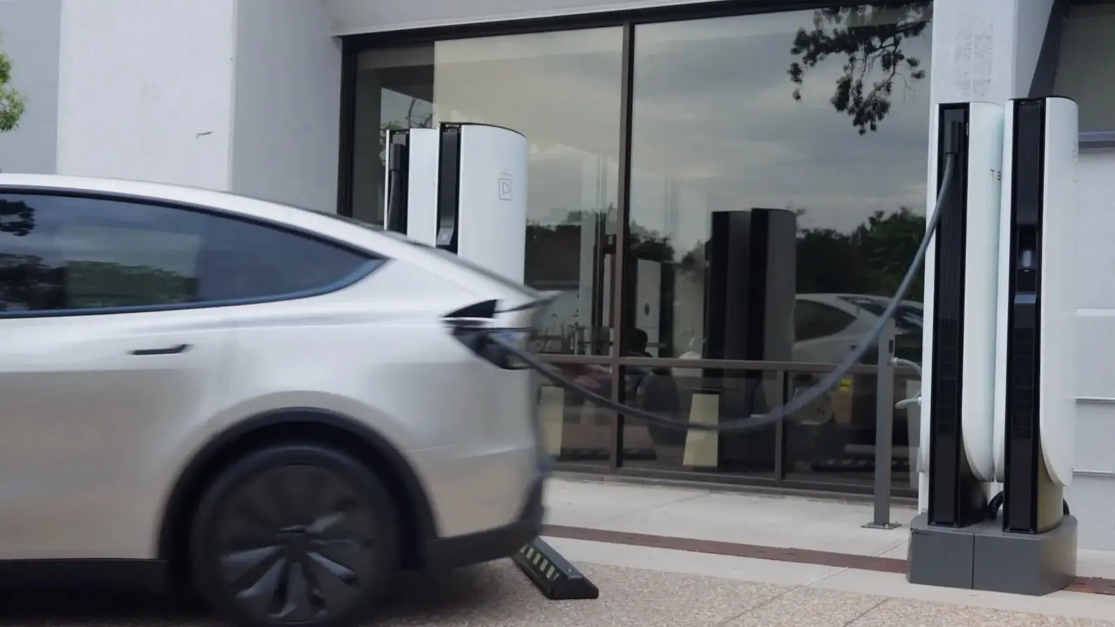 خودروی تسلا (Tesla) در حال حرکت از ایستگاه سوپرشارژر